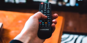 person-using-remote-control-to-change-tv-channel-feature